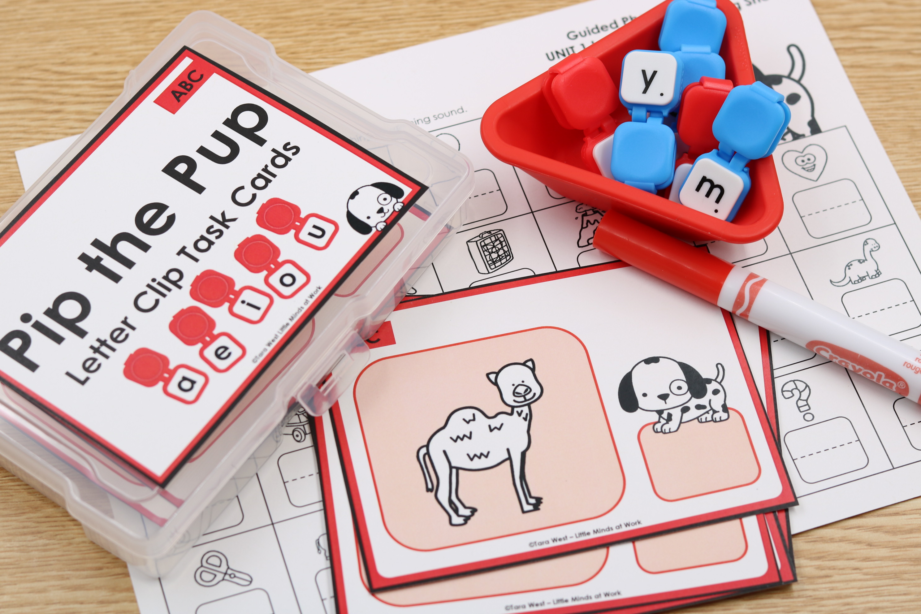 A student clipping a letter to a Pip the Pup image card at a center table