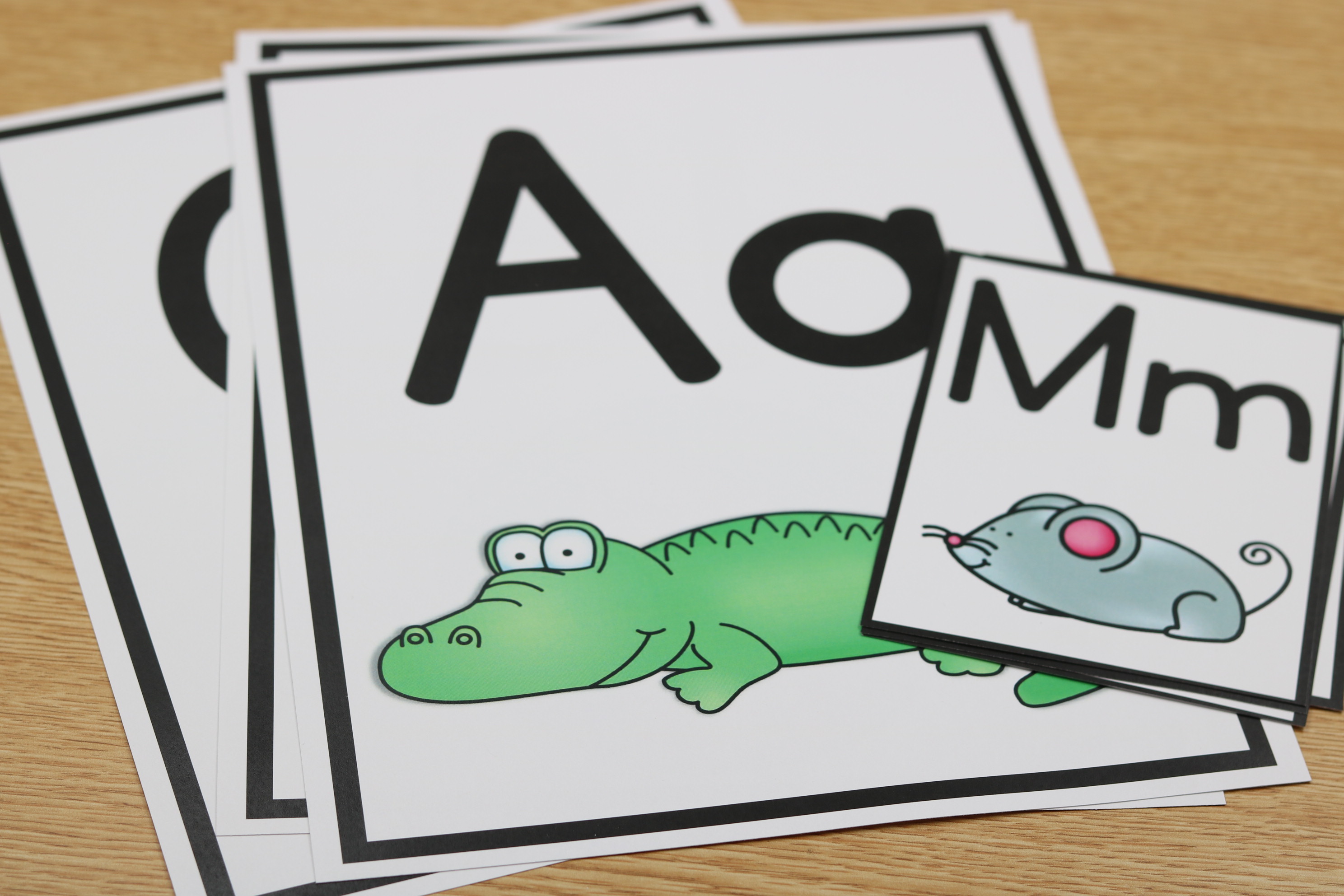 Printable alphabet strip with capital and lowercase letters and fiction-style beginning sound icons.